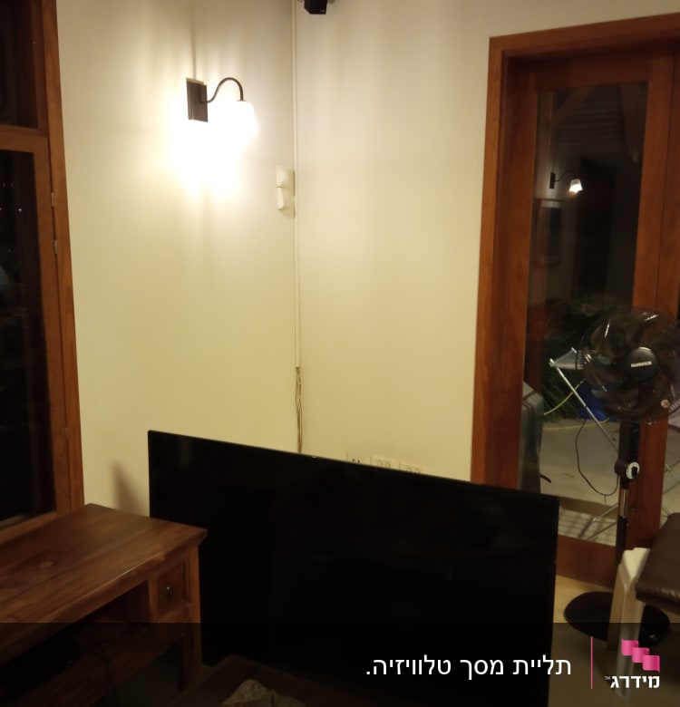 טלוויזיה מונחת על הרצפה ליד שקעי חשמל